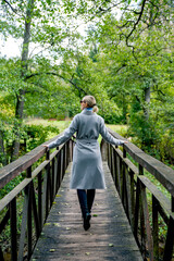Girl with elegant coat walking on the bridge looking to the left
