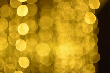 Golden abstract bokeh on black background.