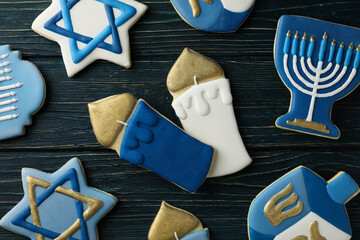 Gingerbread cookies with Jewish symbols on wooden background, top view