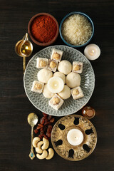 Fototapeta na wymiar Sweets, spices, rice and candles on dark wooden background, top view