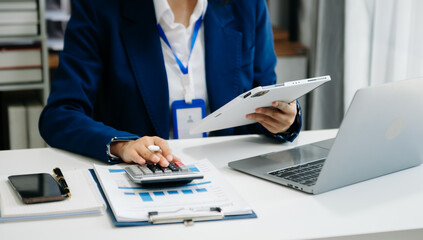 businesswoman working with digital tablet computer and smart phone with financial business strategy layer effect on desk