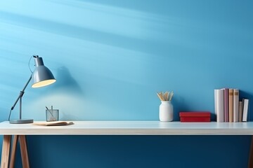 Table with lamp, plant and handles against a blue wall. Workplace, minimalism.