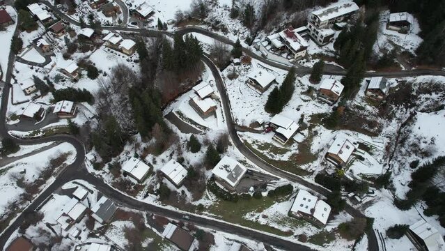 Video plan of a follow-up of a car on a snowy mountain path in a cottage district