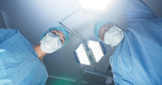Hospital, doctor and lights for surgery, operating room and setting machine. Operation, medical and diagnosis for patient, anesthesia and portrait in POV, teamwork and hands for support, work or job