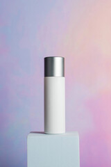 Plastic white tube for cream or lotion. Skin care or sunscreen cosmetic with stylish props on colorful background 