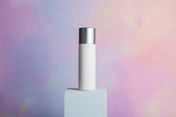 Plastic white tube for cream or lotion. Skin care or sunscreen cosmetic with stylish props on colorful background 