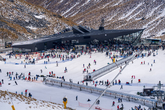 Queenstown, New Zealand - 23 Sep, 2023: Snow covered The Remarkables ski resort bustling with skiers and snowboarders. Chairlifts against mountains transport eager skiers to modern facilities.