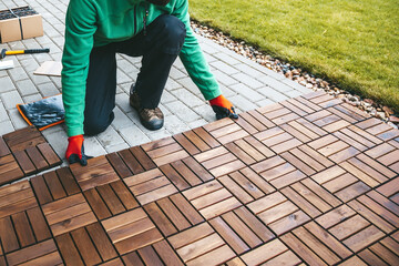 Skilled craftsman laying wood flooring on a terrace