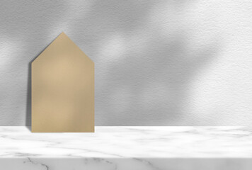 Old Paper House on Marble Table with White Concrete Wall Background with Tree Shadow, Suitable for Product Presentation Backdrop, Display, and Mock up.