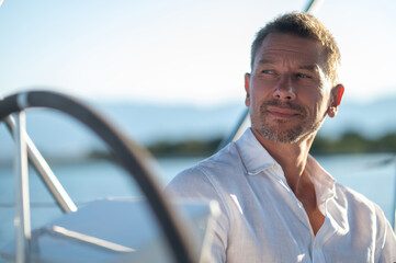 Smiling man traveling on a yacht and looking contented