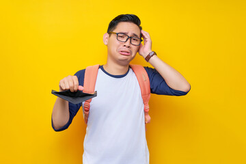 Problem Financial. Sadness young Asian student man in casual clothes and glasses backpack showing...