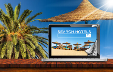 Search hotels website on laptop computer screen, a straw beach umbrella and
a palm tree on clear...