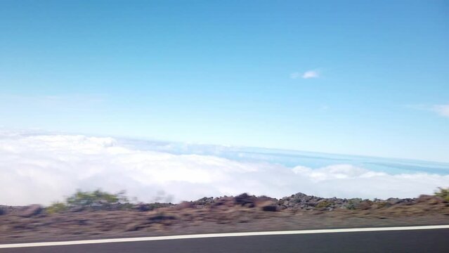 Gimbal POV shot from a moving vehicle driving on a road above the clouds near the summit of Haleakala in Maui, Hawai'i. 4K at 60 FPS Slow Motion