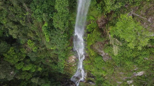 Aerial rises over wispy vine-like jungle waterfall, Cascada el Bejuco