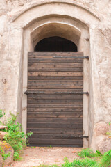 Fototapeta na wymiar old medieval massive wooden entrance door to a masonry building or castle