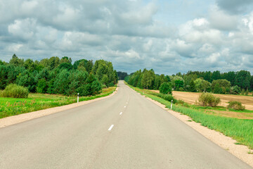 Rural landscape with asphalt road, fields and meadows