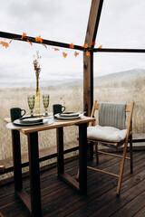 Table setting for breakfast, lunch or dinner. Table for two indoors with panoramic windows amidst nature. Catering, cafe, restaurant
