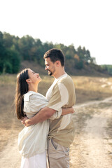 Mature man and woman in the field are hugging.