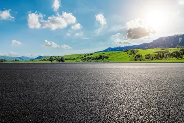 Fototapeten Road and green mountain landscape under blue sky © ABCDstock