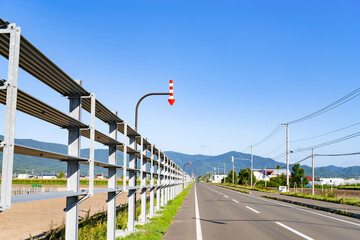 夏の北海道美瑛・富良野　固定式視線誘導柱(矢羽根)のある道路