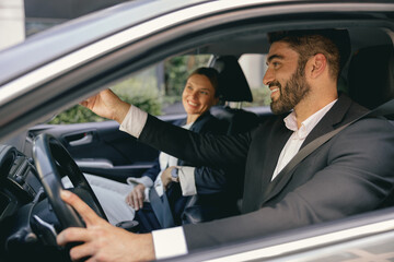 Two positive business colleagues in suit carpooling journey into work together