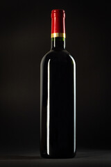 Bottle of red wine on a black background, studio shot.