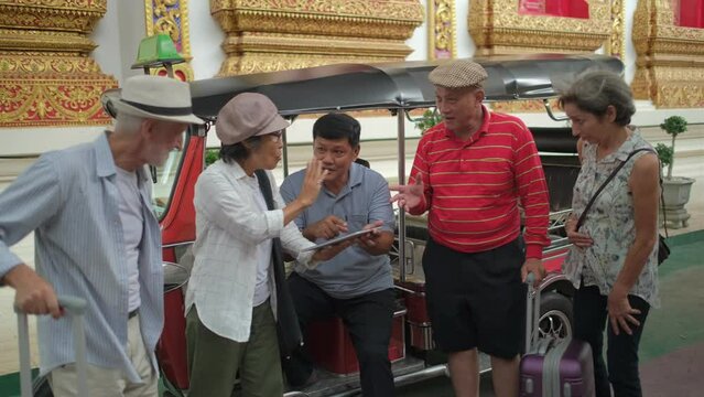 group of senior tourists discuss and bargain tuktuk taxi service and make agreement.