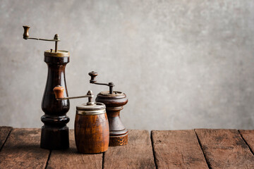 Various kinds of old pepper mills on wooden table