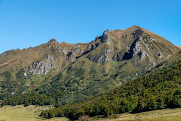 Puy de Sancy vu du coté de la vallée glaciaire de la fontaine salée avec son versant verdoyant par une belle journée ensoleillée dans le puy de dôme sur un chemin de randonnée