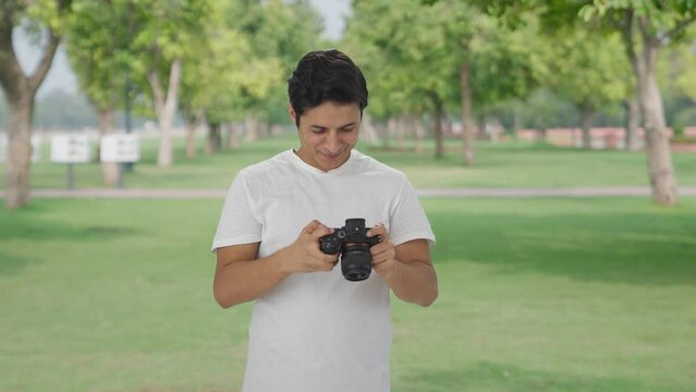 Happy Indian man clicking photos using camera