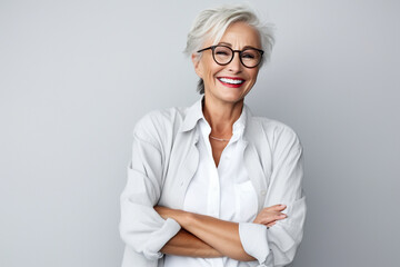 Portrait of attractive elderly happy laughing woman with gray hair wearing glasses over gray background. AI generated