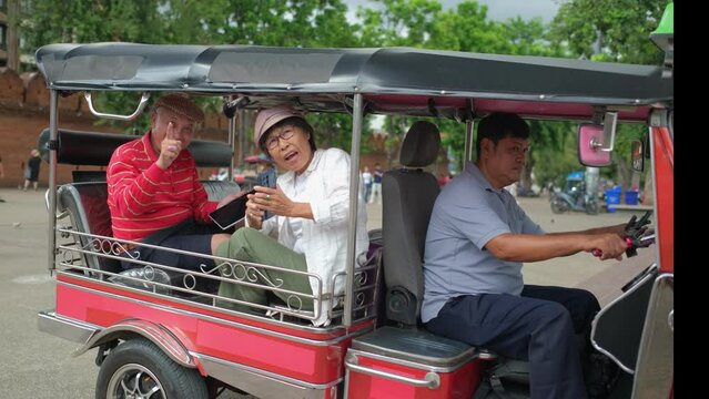 elder couple in a tuktuk taxi ride. stops ang takes photos.