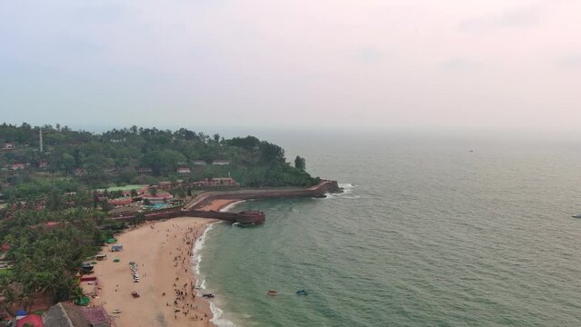 Goa, India: Aerial view of famous Indian summer resort by Arabian Sea, famous Sinquerim Beach and Sinquerim Fort at sunset - landscape panorama of South Asia from above