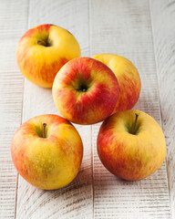 Ripe juicy apples on a light wooden background. Fruit, harvesting.
