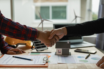 Construction worker and engineer holding hands Real estate concept: architect shaking hands with engineer or builder and successful meeting