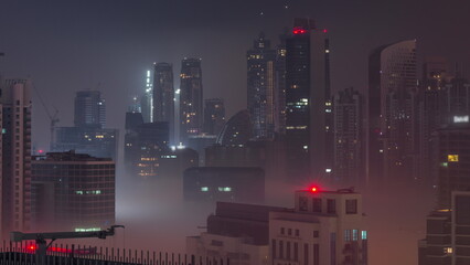 Dubai skyscrapers with illumination in business bay district during all night timelapse.