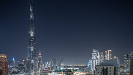 Fototapeta premium Panorama showing aerial cityscape night timelapse with illuminated architecture of Dubai downtown.