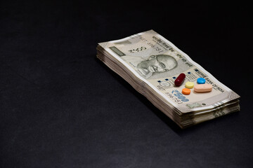 medicine with indian currency on dark background, pharmaceutical business in india