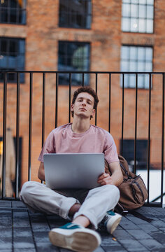 Gen Z student working on laptop after lecture on campus. Young stylish zoomer studiing outdoors. Importance of education of gen Z.