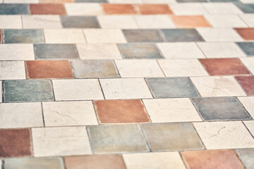 The floor is lined with vintage, geometric patchwork tiles. Texture of stone tiles on the floor...