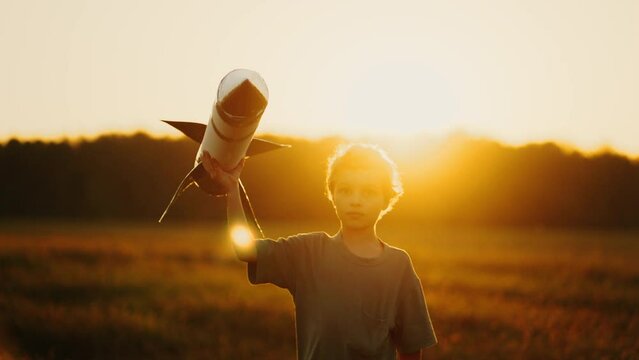 Happy Little Boy Playing With Handmade Toy Rocket In Meadow In Summer In Sunset Time, Happy Moments