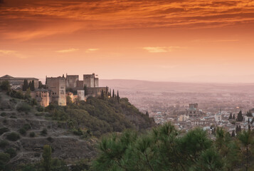 Fototapeta na wymiar The Alhambra in the red sunset is a sight to behold, a fusion of history, architecture, and nature's beauty, where the past and present coalesce in a remarkable and unforgettable scene