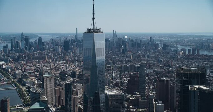 Aerial Footage of a Camera Locked on Top of the One World Trade Center Skyscraper with Antenna. Helicopter Flying Around the Glass Building with a View on Greater New York City Boroughs