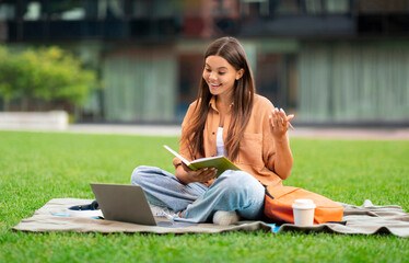 Student engrossed in online learning, using laptop, university backdrop