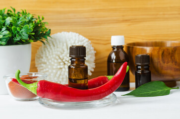 Small bottle with red chili pepper tincture and fresh chili pepper for preparing homemade healing mask anti hair loss. Baldness, alopecia natural remedy. Diy cosmetics and spa recipe.