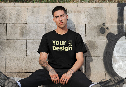 Mockup of man wearing t-shirt with customizable by wall