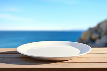 Empty Round White Plate on Beach Table with Blurred Sea and Sky Background