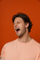 Obraz premium Young man screaming while standing isolated over red background