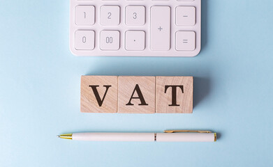 Vat on wooden cubes with pen and calculator, financial concept