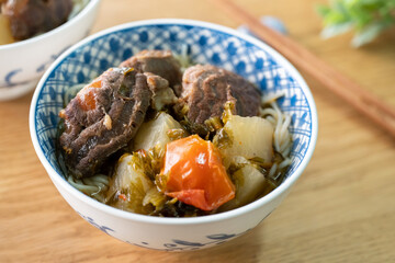 Beef noodle soup. Taiwanese famous food in a bowl on wooden table.